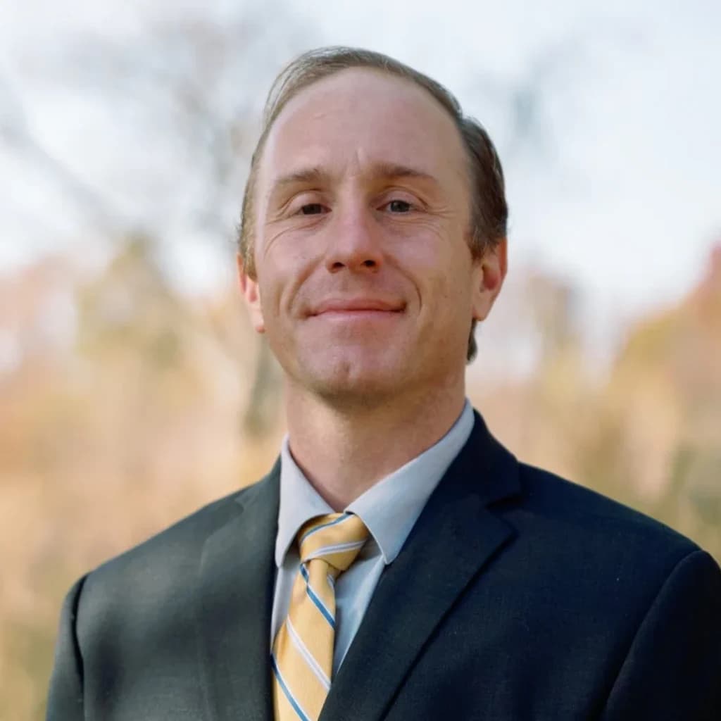 Daniel Tagge, MD, in a navy suit and gold tie
